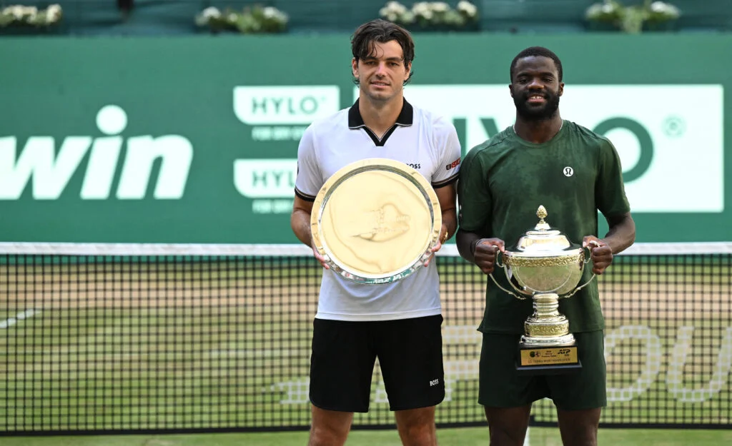 Winner Frances Tiafoe (R) of the US and second placed, his compatriot Taylor Fritz, pose for a picture with their trophies after their men's singles final match of the Halle Open ATP tennis tournament in Halle, western Germany, on June 21, 2026.