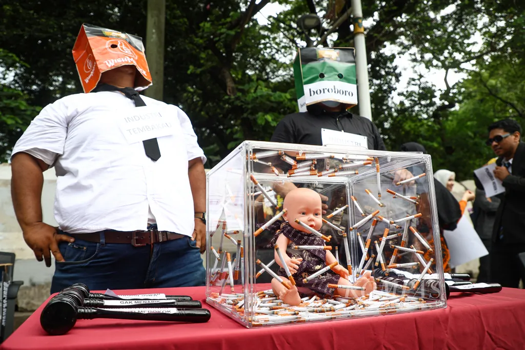 Boks berisi boneka bayi yang dikelilingi puntung rokok ditampilkan dalam aksi memperingati Hari Kesehatan Nasional di kawasan Monas, Jakarta, Rabu (12/11/2025). Aksi bertajuk "Kesepakatan Asap di Meja Rapat: Hak Sehat Rakyat Digadai Cuan Korporasi" ini menyoroti lemahnya kebijakan pengendalian tembakau akibat intervensi industri dan kurangnya komitmen pemerintah dalam melindungi kesehatan publik. Melalui aksi ini, Komunitas Save Our Surroundings (SOS) menyerukan agar negara kembali berpihak pada rakyat, bukan kepentingan industri rokok.

KOMPAS/ADRYAN YOGA PARAMADWYA (YGA)
12-11-2025
