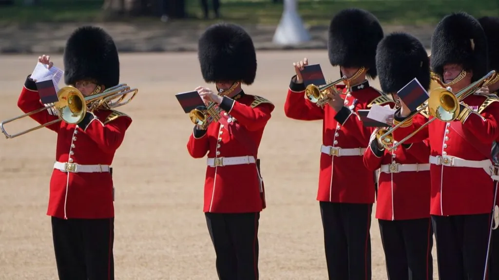 A trombone player in the military band faints during the Colonel's Review, the final rehearsal of the Trooping the Colour, the King's annual birthday parade, at Horse Guards Parade in London, Saturday, June 10, 2023. (Jonathan Brady/PA via AP) Cuaca panas yang melanda London membuat sejumlah tentara Inggris kewalahan menahan panas saat mereka mengenakan tunik wol dan topi kulit beruang saat mengikuti parade